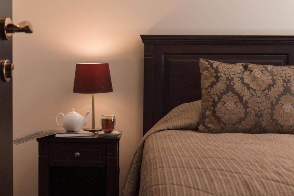 ein Schlafzimmer mit einem Bett mit einer Lampe auf einem Nachttisch in der Unterkunft Pušynė in Birštonas