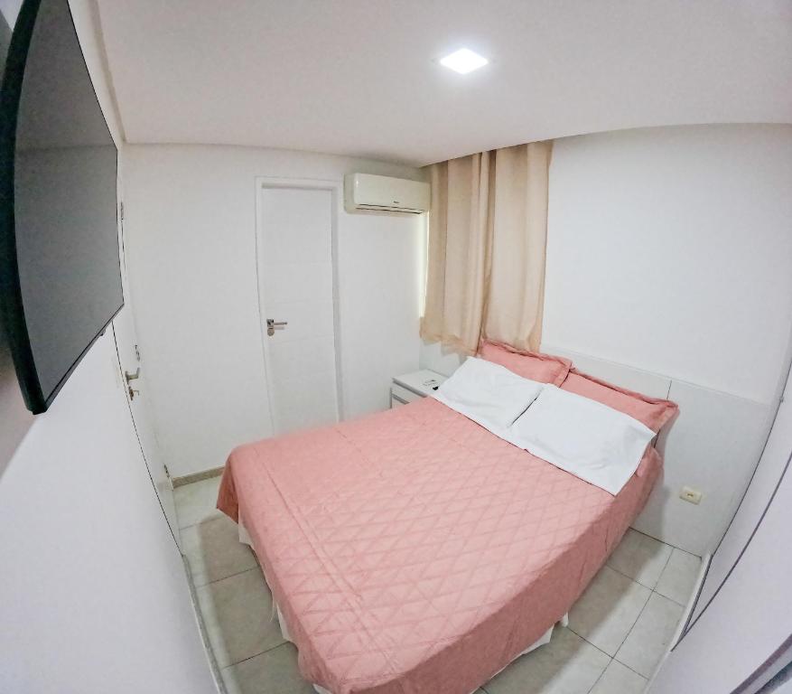 a small bedroom with a pink bed and a window at casa de veraneio - casa 9 - condomínio azul mar - Porto de Galinhas in Porto De Galinhas
