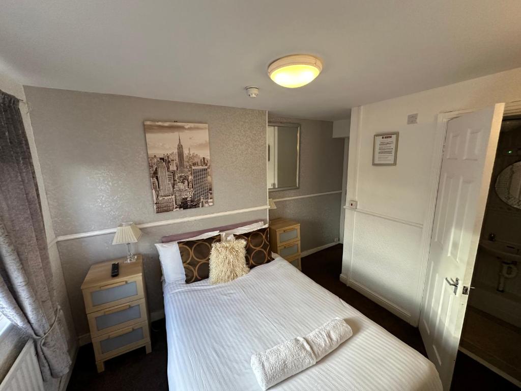 a small bedroom with a bed and a lamp at Ocean Road Rooms in South Shields