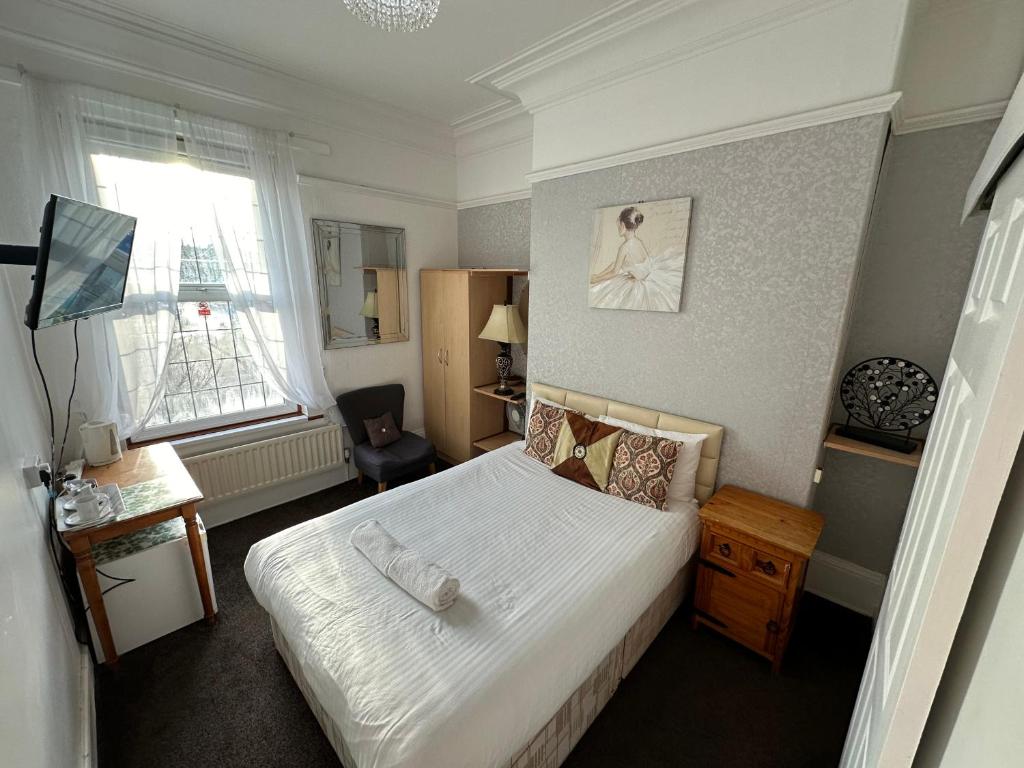 a bedroom with a large bed and a window at Ocean Road Rooms in South Shields