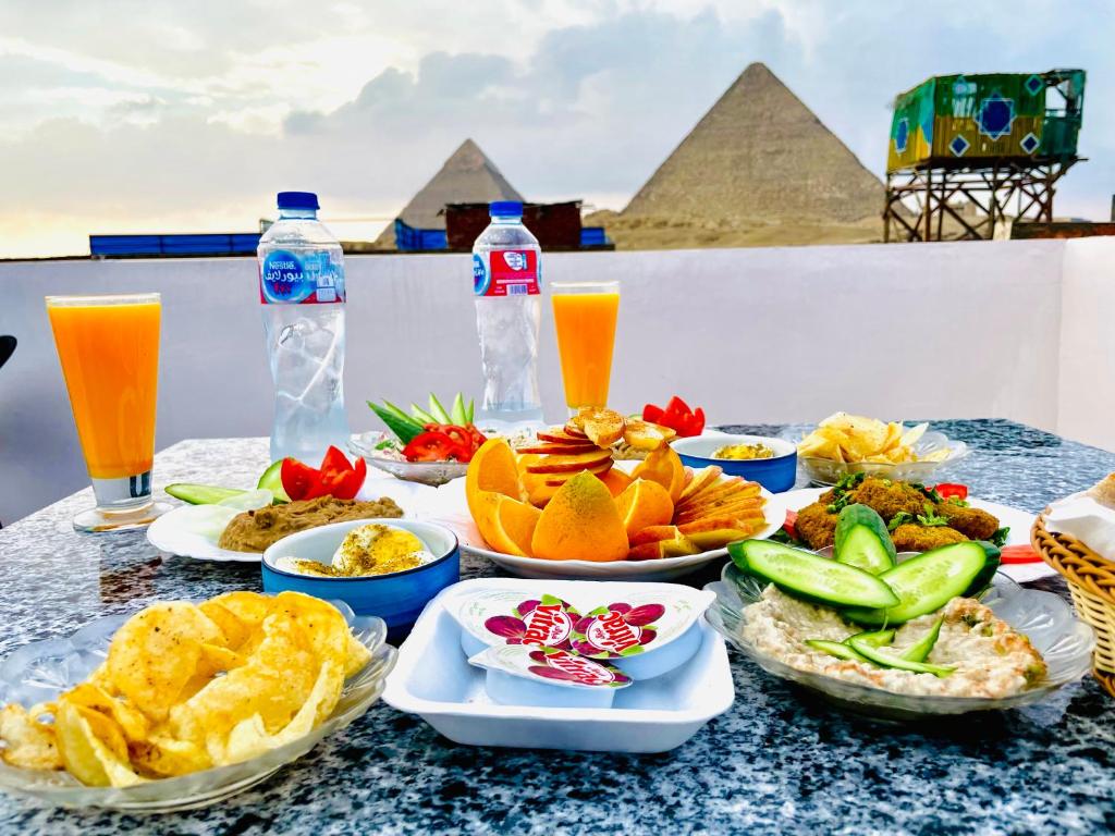 stół z talerzami żywności z piramidami w tle w obiekcie Horus pyramids view w Kairze