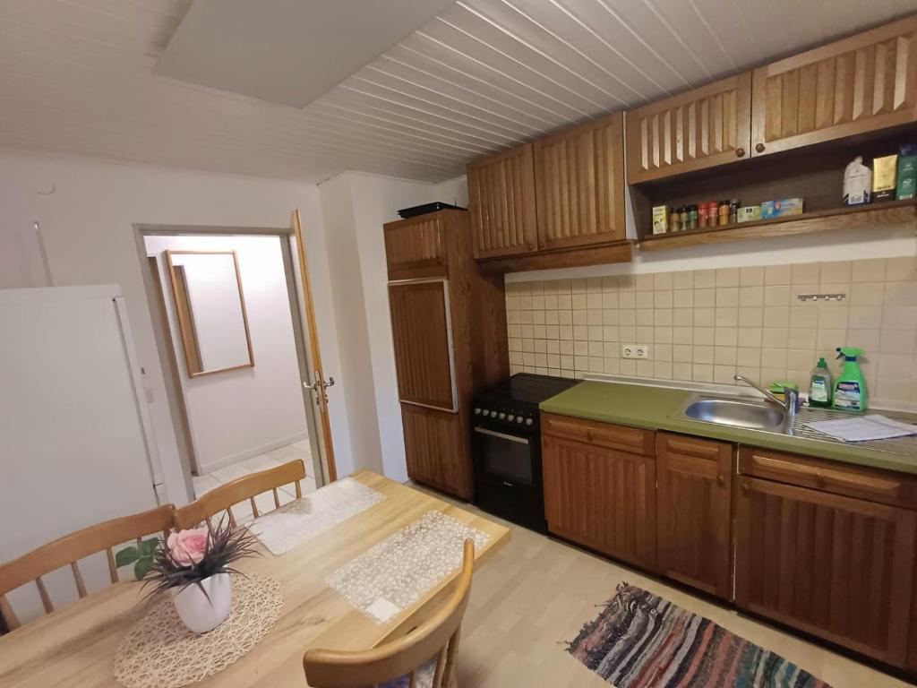 uma pequena cozinha com uma mesa e um lavatório em APARTMENT / WOHNUNG IN HAIBACH em Haibach