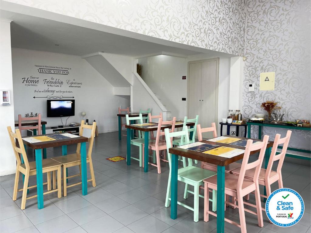 a restaurant with tables and chairs and a tv at Vintage Place - Azorean Guest House in Ponta Delgada