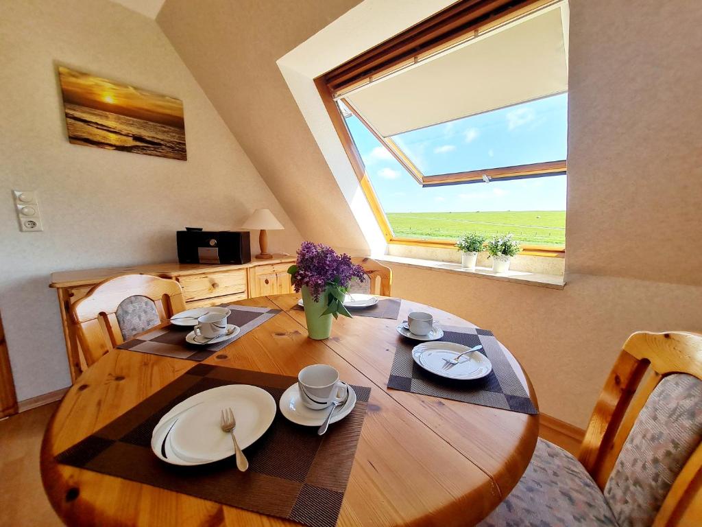 Vollerwiek的住宿－Am Seedeich，木制用餐室配有桌椅和大窗户