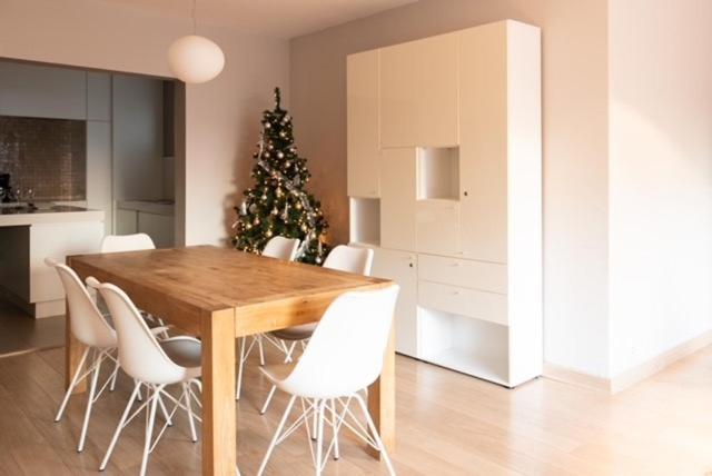 een eettafel met witte stoelen en een kerstboom bij Appartement Nieuwpoort-Bad met garage in Nieuwpoort