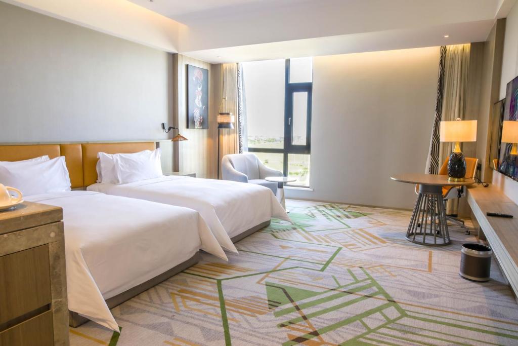 a hotel room with a large bed and a window at Argyle Grand Hotel Nairobi Airport in Nairobi