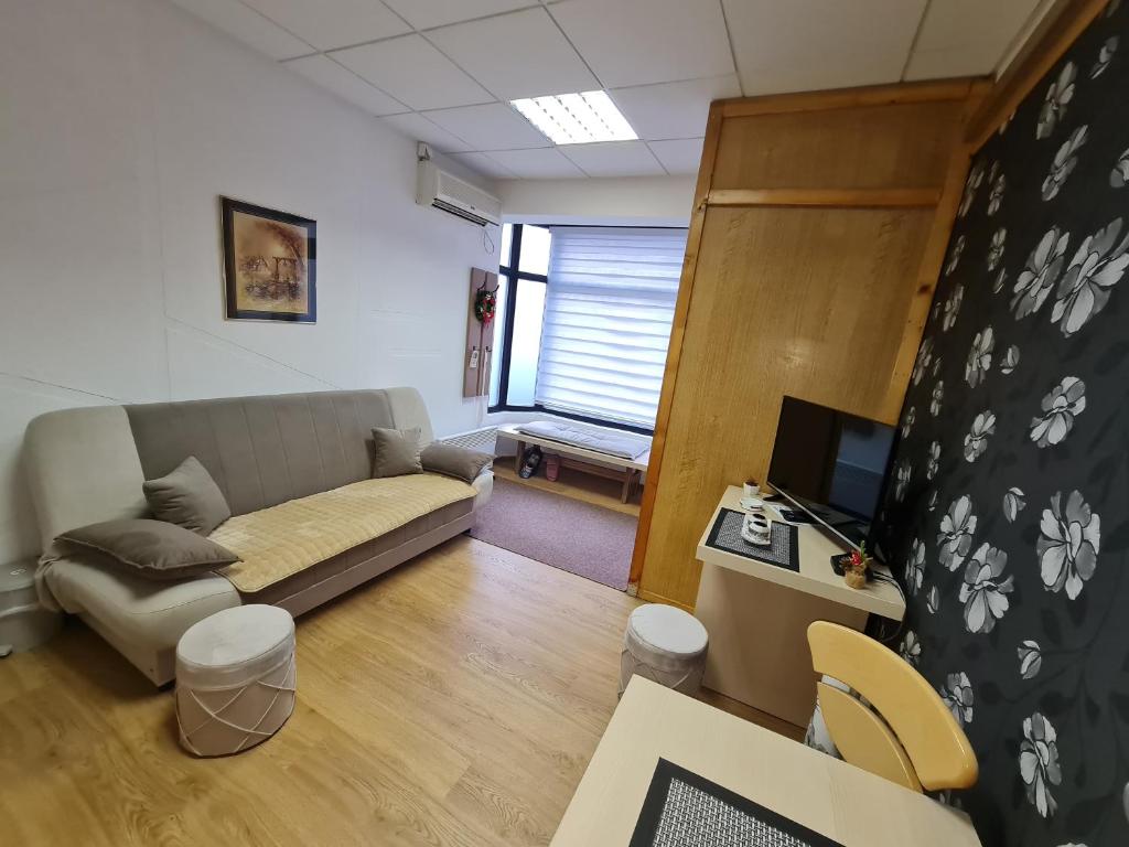 a living room with a couch and a desk with a television at Apartment Čolović in Raška