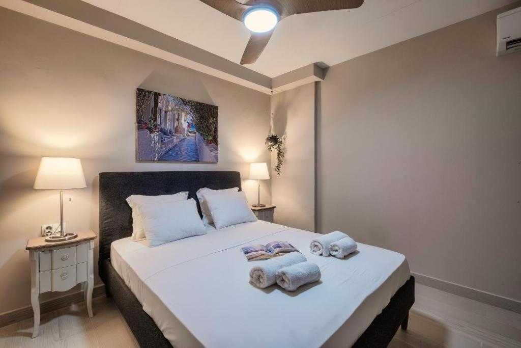 um quarto com uma grande cama branca com toalhas em Varkiza Beach House em Vári