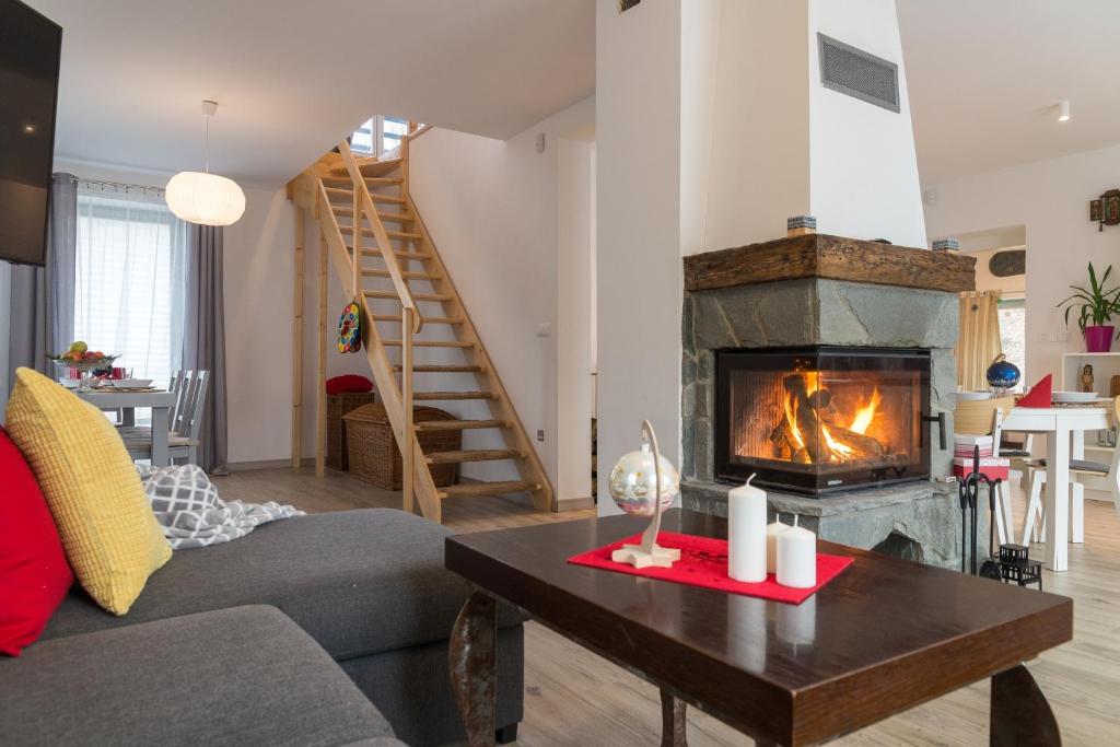 a living room with a couch and a fireplace at VacationClub - Nadrzeczna VacationHome 1 in Ustroń