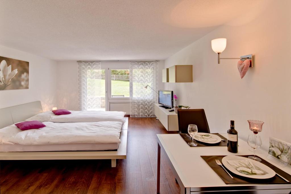 采爾馬特的住宿－Ferienwohnung Bahari Zermatt，一间卧室配有床和一张带盘子及玻璃杯的桌子
