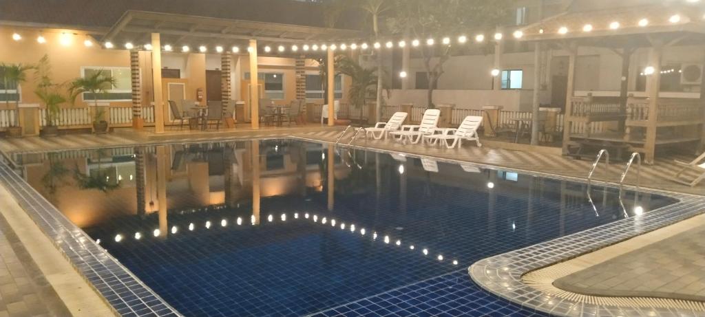 een groot zwembad met stoelen en tafels in een gebouw bij Tèja Hotel in Bangkok