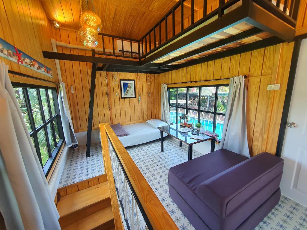 บ้านนกฮูกอิงไม้ ริมเล في Ban Khlong Sai: غرفة معيشة مع أريكة وطاولة