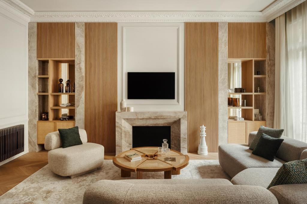 un salon avec une cheminée et une télévision dans l'établissement Appartement Luxe et Rénové - Champs-Élysées, à Paris