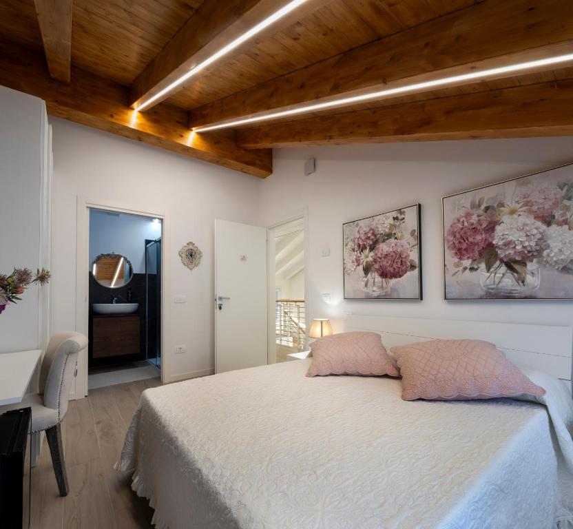 ein Schlafzimmer mit einem Bett und zwei Gemälden an der Wand in der Unterkunft Camerini Guest House in Piazzola sul Brenta