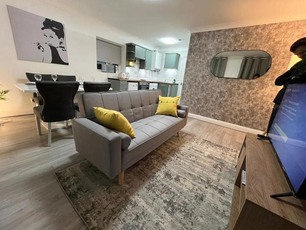 ein Wohnzimmer mit einem Sofa und gelben Kissen in der Unterkunft Contemporary Style in the Heart of London in London