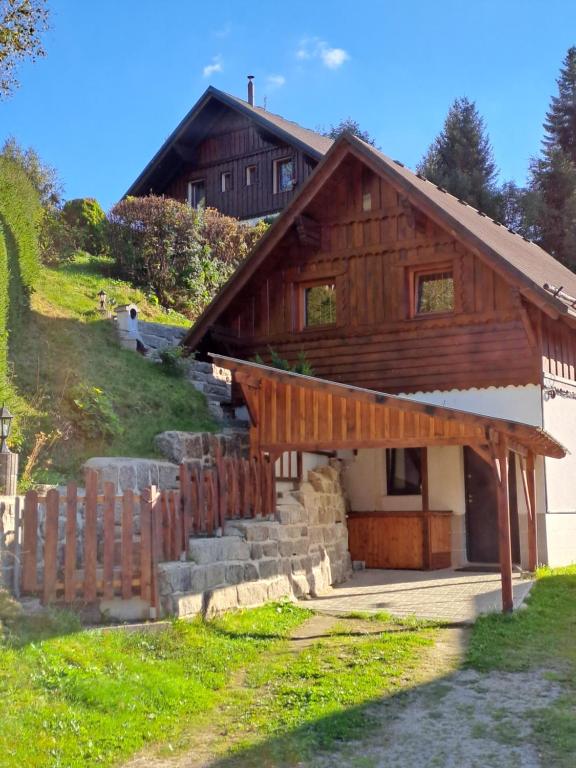 ein Holzhaus mit einem Zaun davor in der Unterkunft Apartmán Albrecht in Albrechtice v Jizerských horách