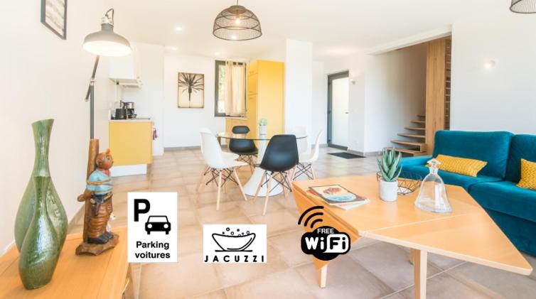 Una sala de estar con un sofá azul y una mesa. en Open Sun avec Jacuzzi Privatif et parking privé, en Sarlat-la-Canéda