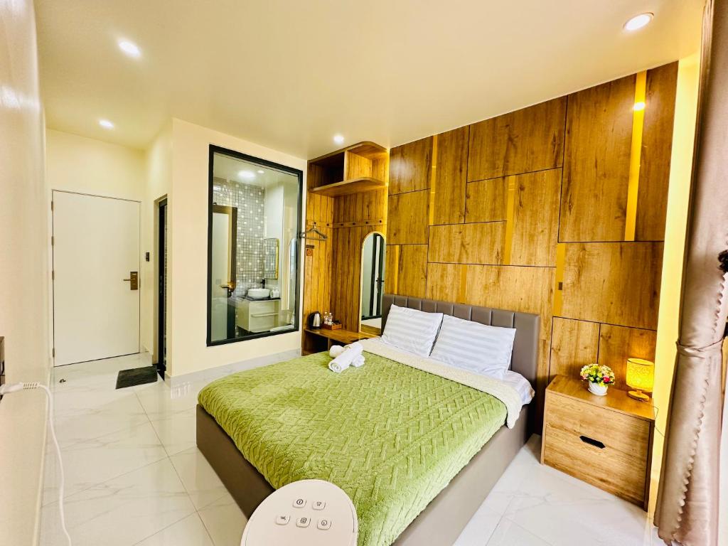 una camera da letto con un grande letto con una coperta verde di Agape Hotel & Căn hộ Đà Lạt a Da Lat