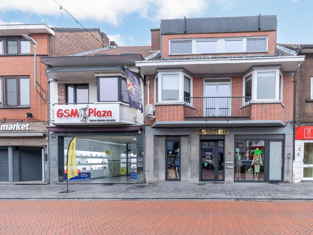 a building with a sisu pizza store on a street at Duplex Apartment in the shopping street of Maasmechelen in Maasmechelen