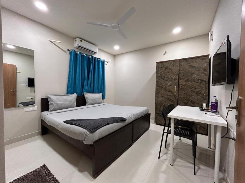 a bedroom with a bed and a desk and a television at Nectar Living - Iris in Hyderabad