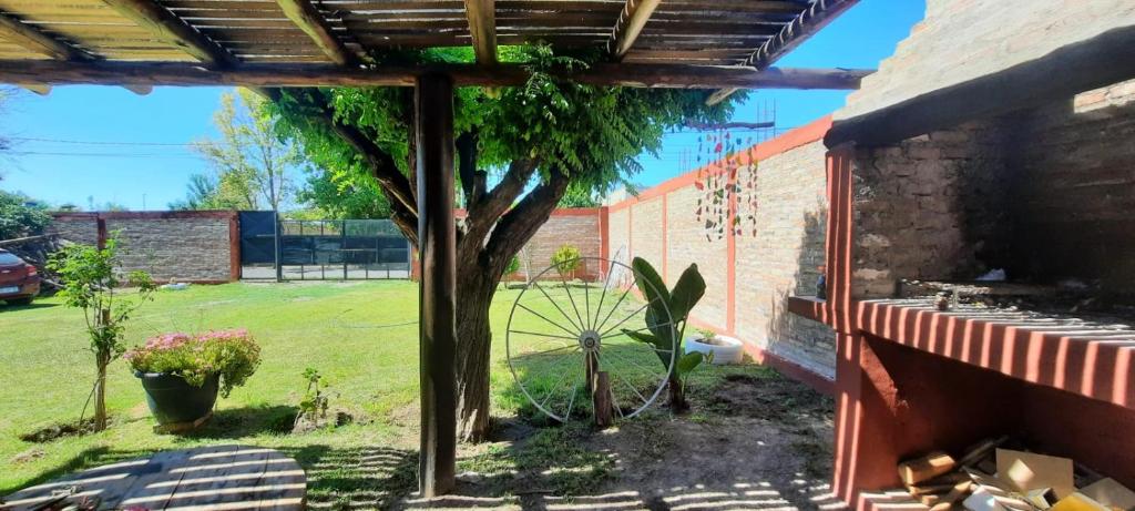 een boom in een tuin naast een gebouw bij F R F departamentos turisticos Nº 2 in San Rafael