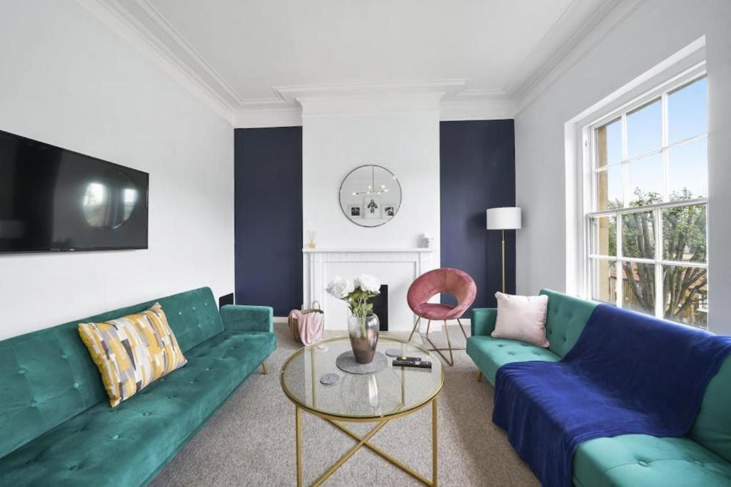 a living room with a blue couch and a table at Spacious 3 Bedroom Flat in Central Bath - Sleeps 8 in Bath