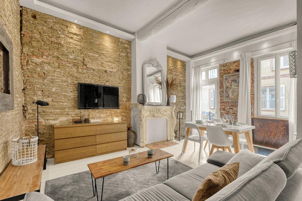 - un salon avec un mur en briques dans l'établissement Le Cilaos - Superbe appt en centre ville, à Toulouse