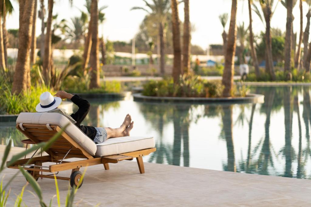 a man laying on a chair next to a pool at The View Agadir in Agadir