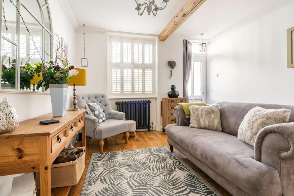 a living room with a couch and a table at Bijou Cottage in Deal
