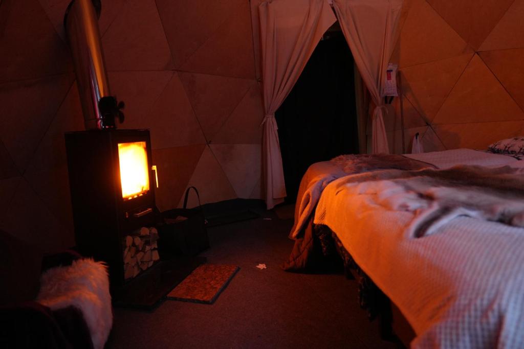 Postel nebo postele na pokoji v ubytování Aurora Igloo Fireplace-heated Tents in a secret forest with private Jacuzzi and shared sauna bathroom and dog friendly