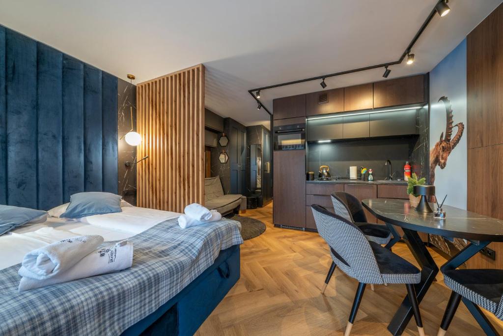 a bedroom with a bed and a table with chairs at Canin Mountain Lodge in Sella Nevea