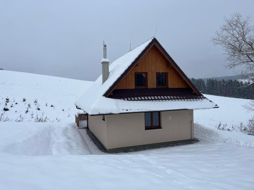 uma pequena casa com neve no telhado em Chata u Jána em Zákamenné