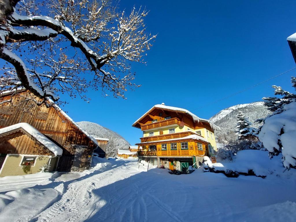 a large building with snow on the ground next to buildings at Wagnerhof in Pichl bei Aussee