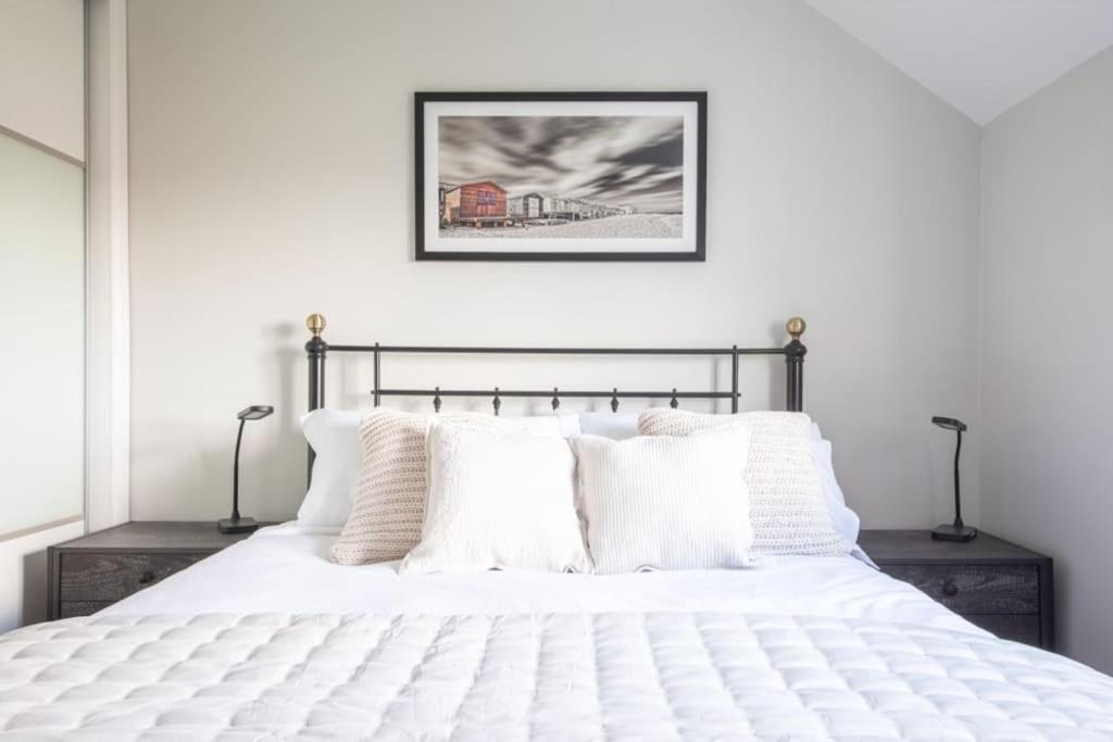 a bedroom with a white bed with white pillows at Olive Tree Townhouse, with parking in Whitstable