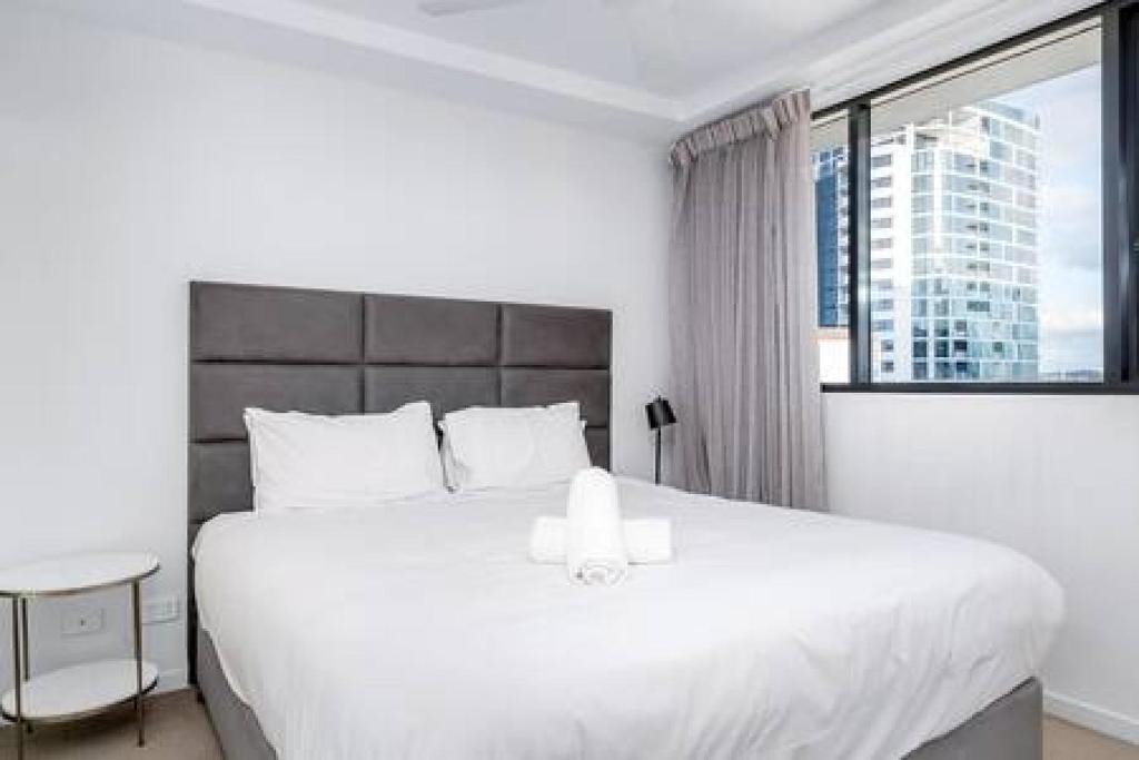 una camera da letto con un grande letto bianco e una finestra di Boutique Portside 1BR, Convenient in Hamilton a Brisbane