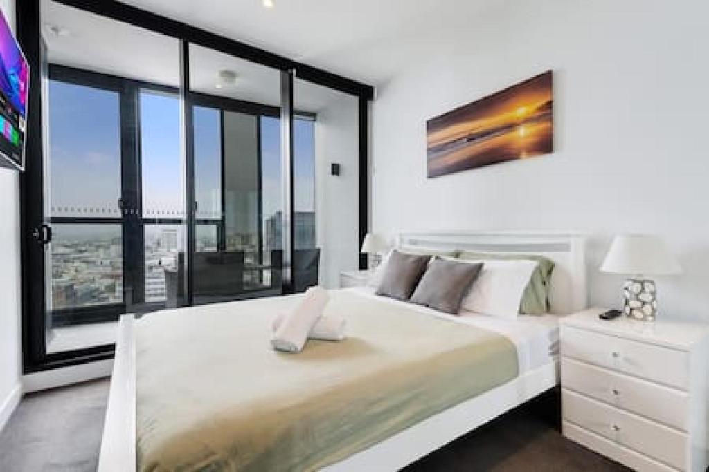 1 dormitorio con 1 cama grande y ventana grande en Stunning bridge view on a high floor FPKG en Brisbane