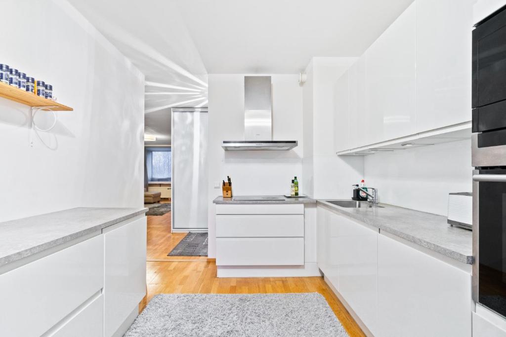 ヘルシンキにある2 room apartment in Pasilaの白いキャビネットとキッチンアイランド付きの白いキッチン