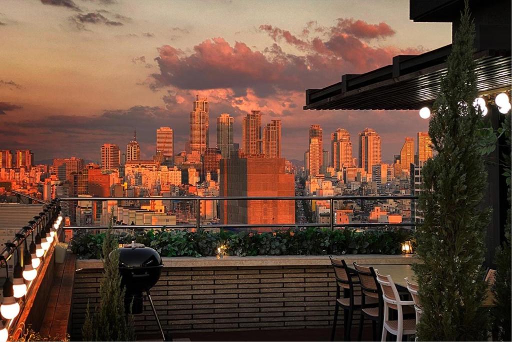 a view of a city skyline from a rooftop restaurant at Garden Pool Villa Lee Chung Jung in Seoul