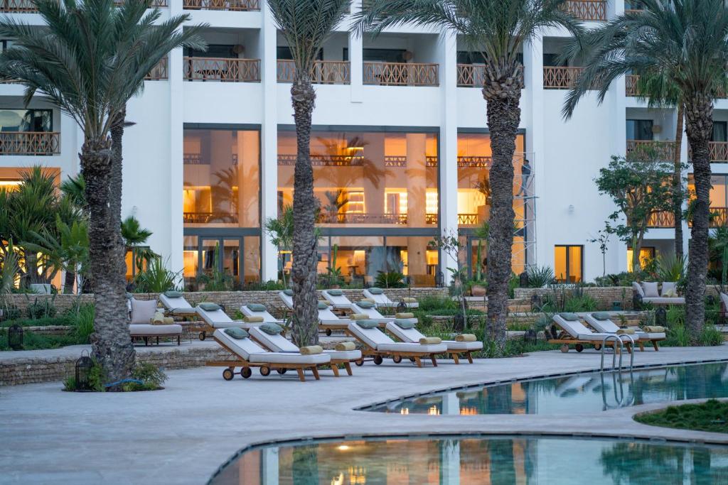 a hotel with palm trees and a swimming pool at The View Agadir in Agadir