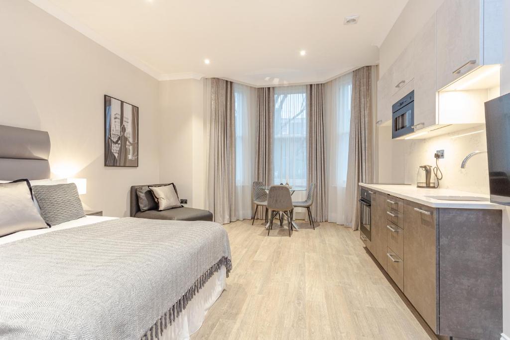 a hotel room with a bed and a kitchen at Cleveland Residences Chelsea in London
