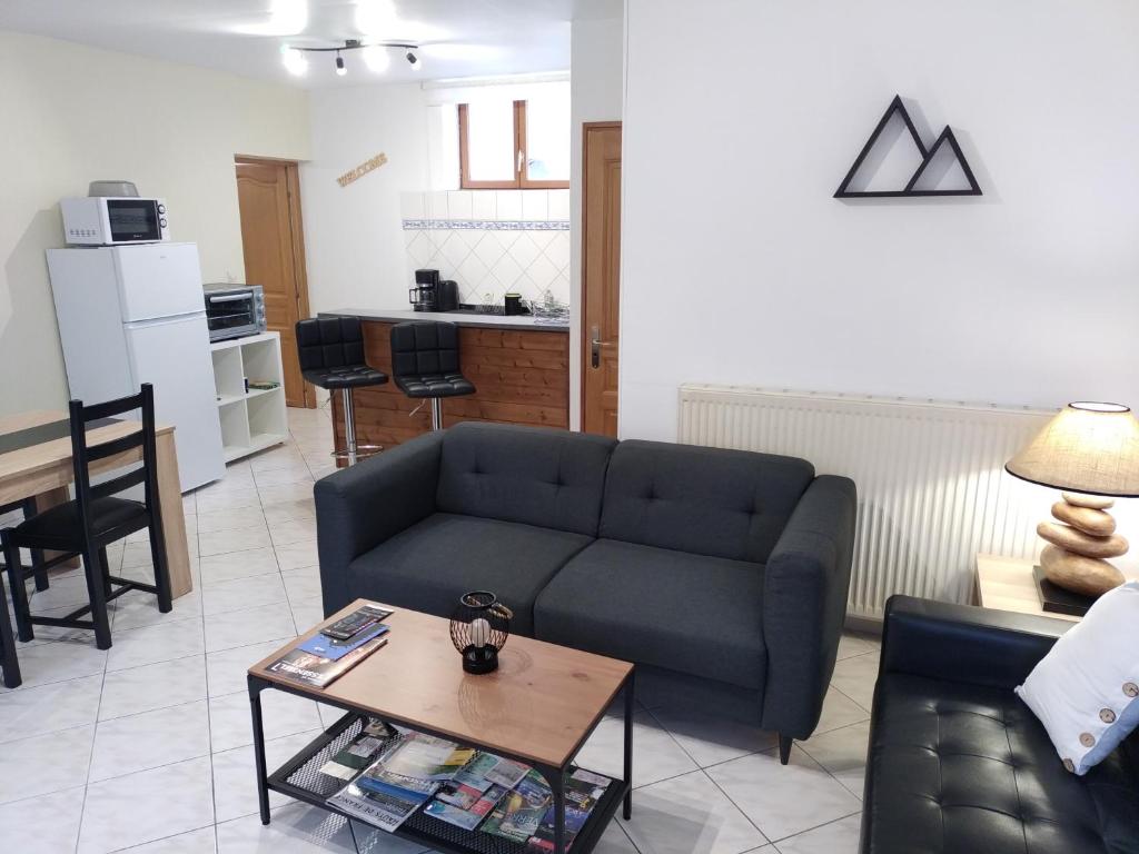 ein Wohnzimmer mit einem Sofa und einem Tisch in der Unterkunft Les Gîtes d'Angres - Gîte n°3 in Angres