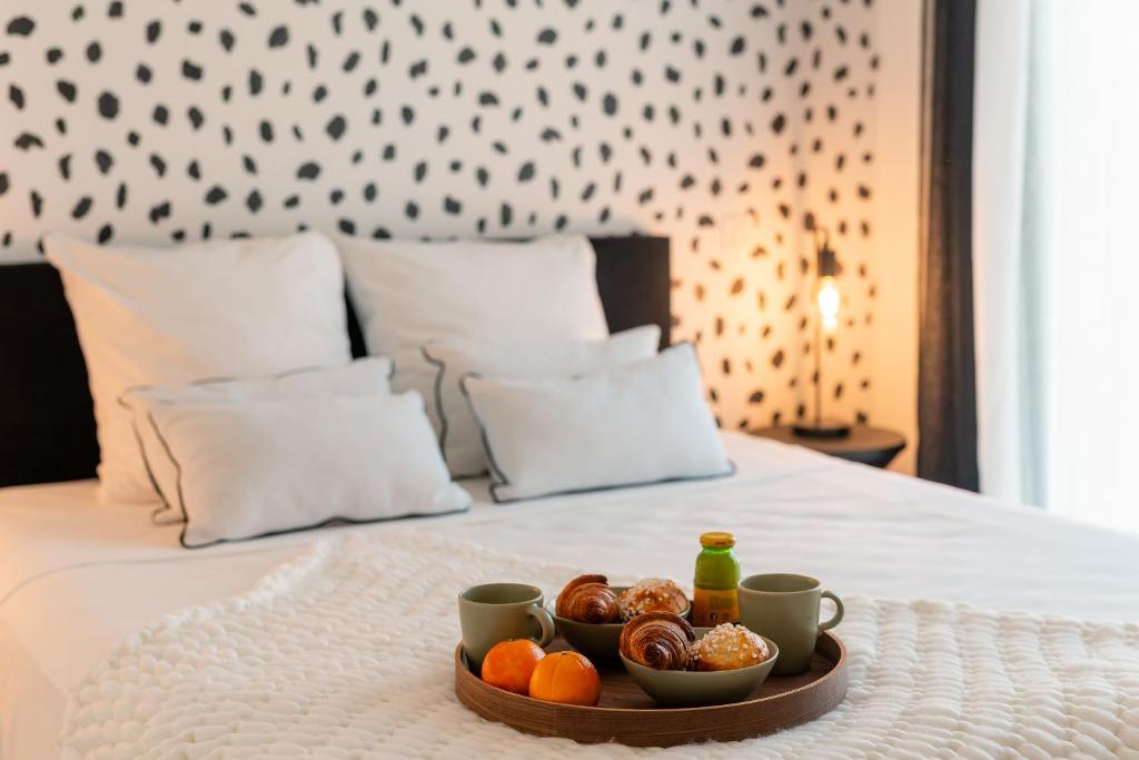 - un plateau de nourriture sur un lit avec des tasses et des oranges dans l'établissement Villa Selva, Plage à 500m, à Sérignan