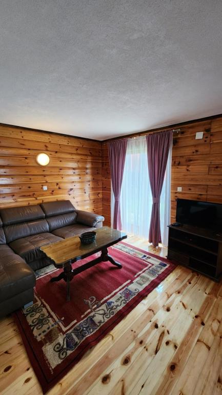 a living room with a couch and a coffee table at Olja Guest House in Žabljak