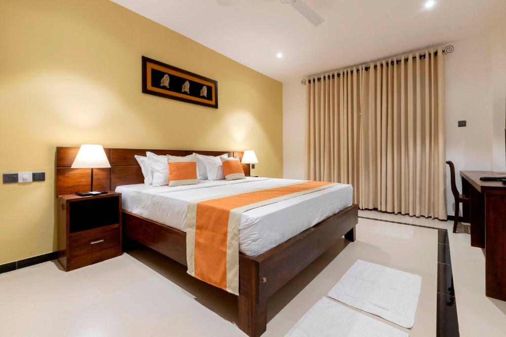 a bedroom with a large bed and a desk at Coastal Villa Mirissa in Mirissa