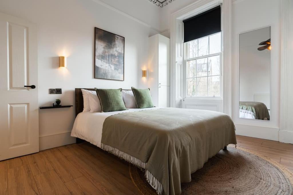 a bedroom with a large bed with green pillows at The West End Retreat - Your Luxurious 5* Apartment in Glasgow