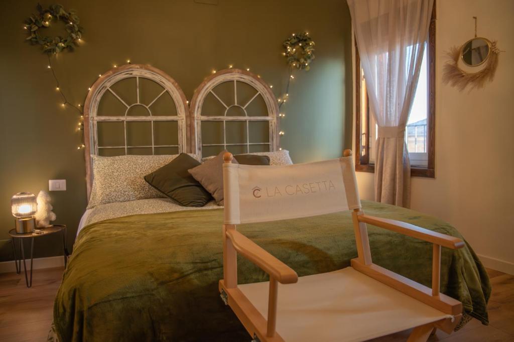1 dormitorio con 1 cama con silla en La Casetta. Feel at home., en Castelfidardo