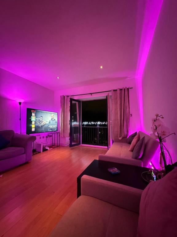 a living room with purple lighting and a couch at Spacious Apartment with Balcony in Leicester
