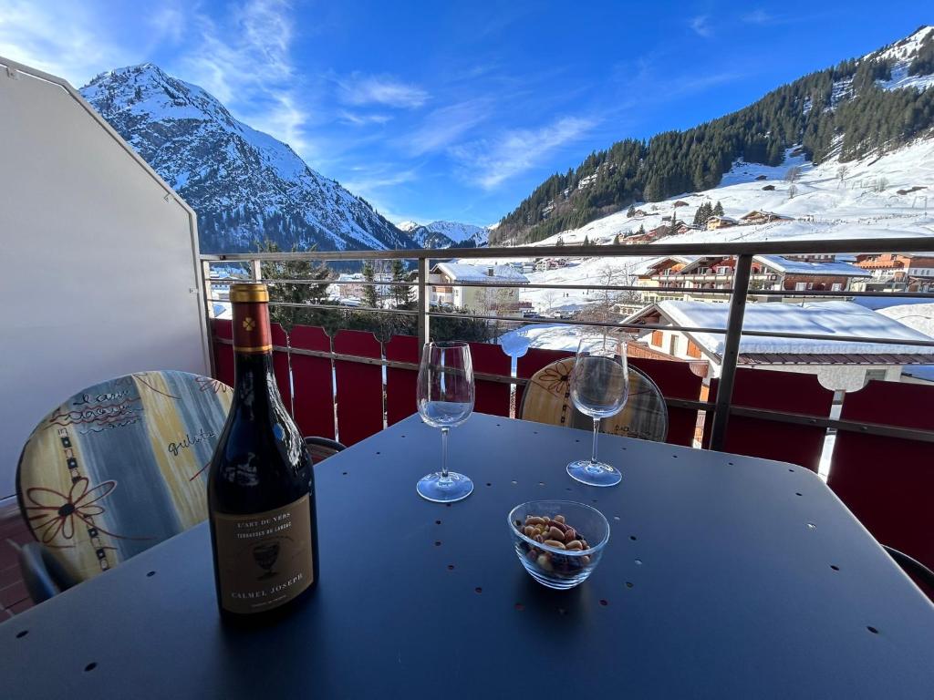 a bottle of wine and two glasses on a table at Appartement 413 Kunners Oostenrijk in Mittelberg