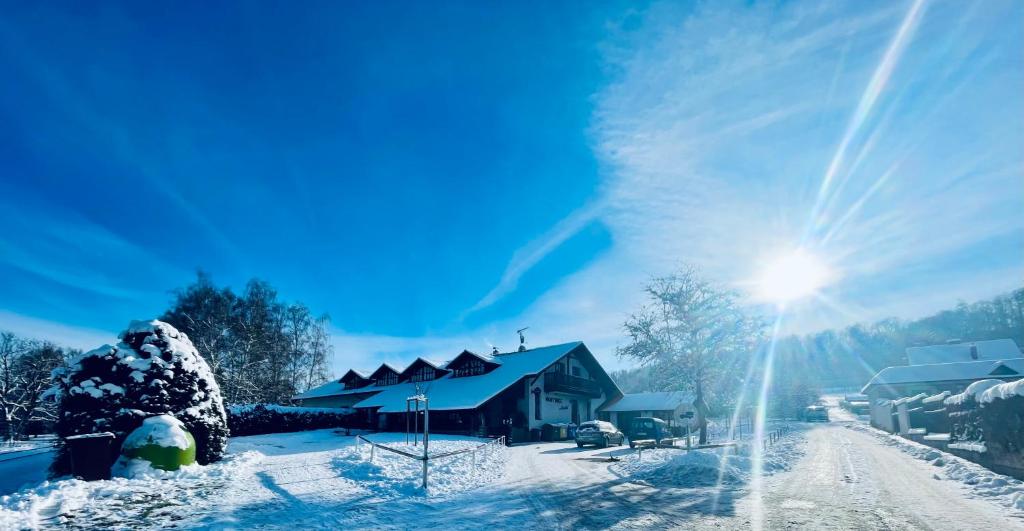 una casa en la nieve con el sol brillando en Hvězdonice Hostinec U Kuželků, en Hvězdonice