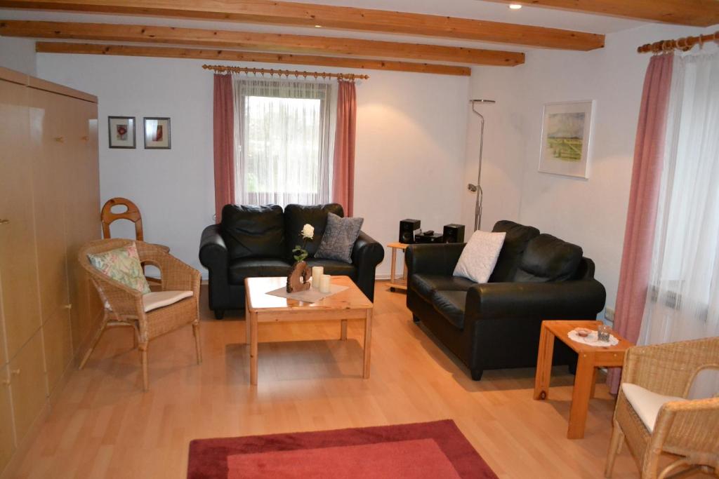 uma sala de estar com mobiliário de couro preto e uma mesa em EG Inge em Katharinenheerd